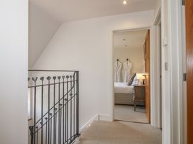 A hallway with a stair railing and a door leading to a bedroom at White House in Montgomery