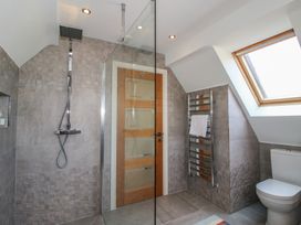 A bathroom with a shower, toilet, and towel rack at White House in Montgomery