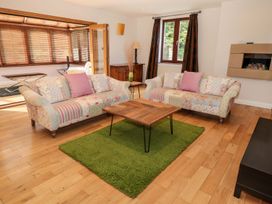 A living room with two floral sofas a wooden coffee table on a green rug and wooden floors at Walworth Castle Lodge in Walworth near Darlington