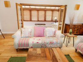 A living room with a patchwork patterned sofa pillows wooden coffee table and wooden sideboard at Walworth Castle Lodge Walworth near Darlington