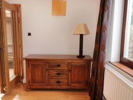 A wooden sideboard with a table lamp next to a window in a room at Walworth Castle Lodge in Walworth near Darlington