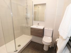 A bathroom with a shower enclosure a wall-mounted sink with cabinet a toilet and towels at Walworth Castle Lodge in Walworth near Darlington
