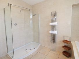 A bathroom with a walk-in shower and towel rack with towels at Walworth Castle Lodge in Walworth near Darlington