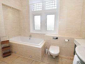 A bathroom with a bathtub toilet sink and frosted windows at Walworth Castle Lodge in Walworth near Darlington