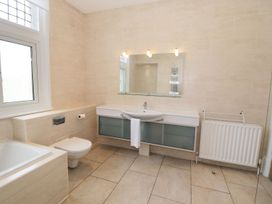 A bathroom with a bathtub toilet sink mirror radiator and window at Walworth Castle Lodge in Walworth near Darlington