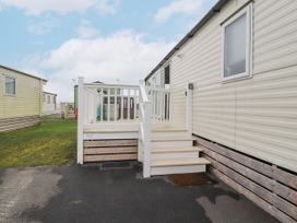 An exterior view of a static caravan with white steps leading to a small deck area at Plot LD19 in Heysham