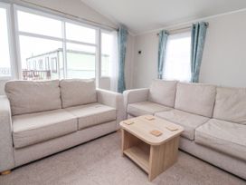 A living room with two beige sofas and a wooden coffee table at Plot LD19 in Heysham