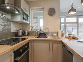 A kitchen with a stove oven microwave kettle toaster sink and countertop at 1 Kessingland Cottages in Kessingland