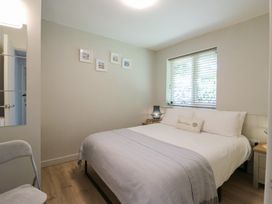 A bedroom with a bed pillows and a window with blinds at 1 Kessingland Cottages in Kessingland