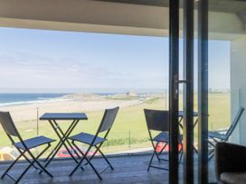 A balcony with a table and chairs overlooking the ocean at Apartment 8