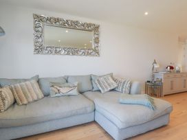 A living room with a sofa and a mirror at Apartment 8 
