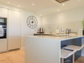 A kitchen with appliances and stools at Apartment 8 in 