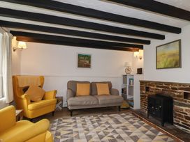 A living room with yellow armchairs and a sofa at Honeysuckle Cottage Charlestown