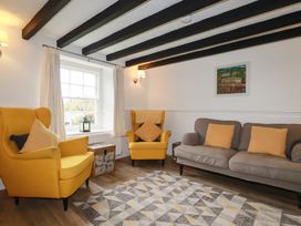 A living room with yellow armchairs and a grey sofa at Honeysuckle Cottage in Charlestown