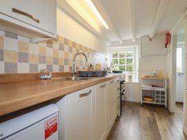 A kitchen with a sink and stove at Honeysuckle Cottage in Charlestown