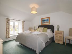 A bedroom with a bed and bedside tables at Honeysuckle Cottage, Charlestown