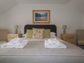 A bedroom with a bed and bedside tables at Honeysuckle Cottage in Charlestown