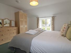 A bedroom with a bed and dresser at Honeysuckle Cottage in Charlestown