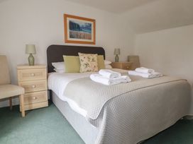 A bedroom with a bed and nightstands at Honeysuckle Cottage in Charlestown