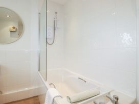 A bathroom with a bathtub and shower at Honeysuckle Cottage in Charlestown