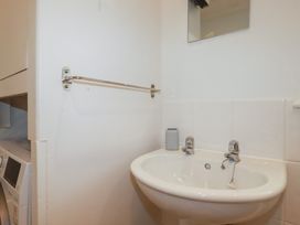 A bathroom with a sink and mirror at Honeysuckle Cottage in Charlestown