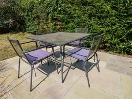 A table and chairs in a garden at Honeysuckle Cottage in Charlestown
