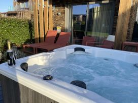An outdoor area with a hot tub and two chairs at Villa 80 in Carbis Bay
