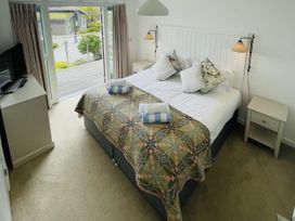 A bedroom with a bed and sliding door at Una, Lodge 73, Carbis Bay