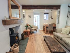 A living room with a fireplace and dining area at Daffodils in Ambleside
