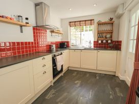 A kitchen with red tiles and appliances at Daffodils in Ambleside