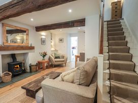 A living room with a sofa, coffee table, and fireplace at Daffodils in Ambleside