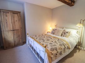 A bedroom with a bed and wardrobe at Daffodils in Ambleside