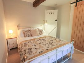 A bedroom with a bed and nightstand at Daffodils in Ambleside
