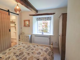 A bedroom with a bed and wardrobe at Daffodils in Ambleside