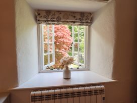 A window with a vase of flowers and a radiator at Daffodils in Ambleside