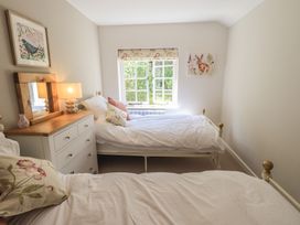 A bedroom with two beds and a window at Daffodils in Ambleside