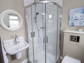 A bathroom with shower, sink, and mirror at Driftwood in 