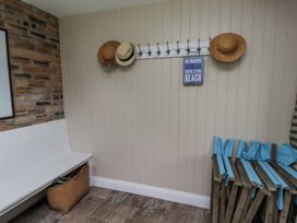 A coat rack with hats and a sign in a hallway at Driftwood