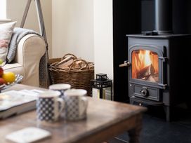 A living room with a fireplace and sofa at Driftwood in Embleton