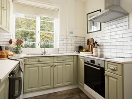 A kitchen with cabinets and a sink at Driftwood in Embleton