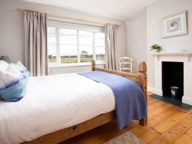 A bedroom with a bed and window at Driftwood in Embleton