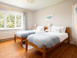 A bedroom with two beds and a window at Driftwood in Embleton