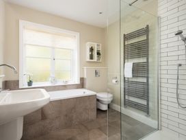 A bathroom with a bathtub, shower, and sink at Driftwood in Embleton
