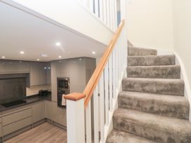 A staircase leading to upper level with kitchen in view at Boslowen Portreath