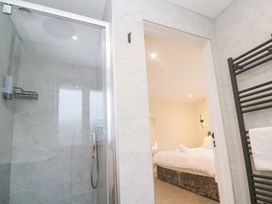A bathroom with a shower and doorway to a bedroom at Boslowen Portreath