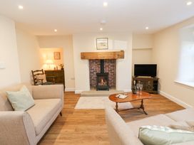 A living room with a fireplace tv sofas and a wooden coffee table at 1 Brookside in Warcop