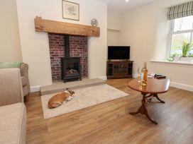 A living room with a fireplace and a television at 1 Brookside Warcop