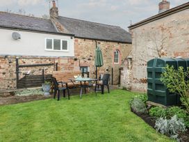 A garden with a table and chairs at 1 Brookside in Warcop