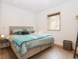A bedroom with a double bed bedside tables lamps and a window at Ty Chwarel in Menai Bridge