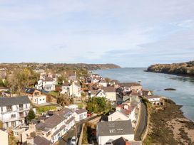 A coastal village with houses along a river and a road by the shore at Ty Chwarel in Menai Bridge